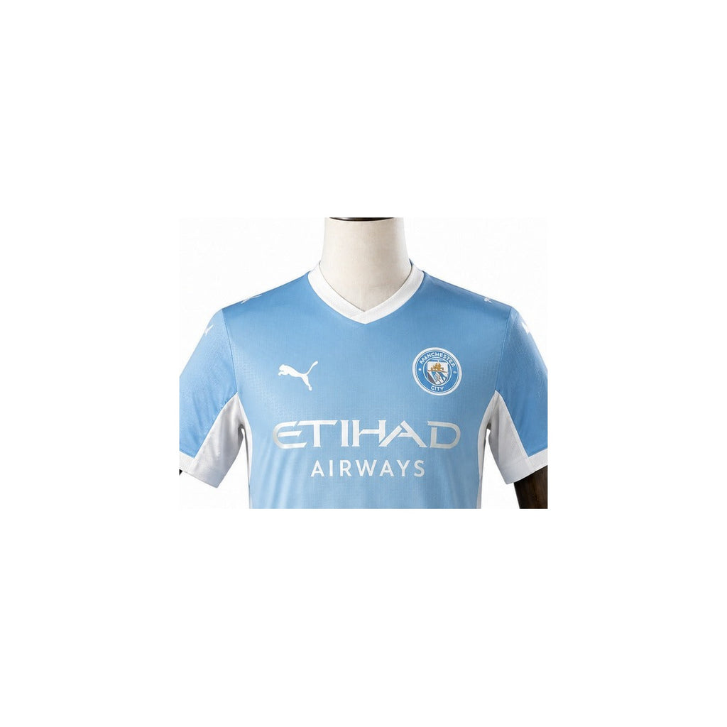 Camisa Manchester City - 1º Uniforme Jogador 2025/26 detalhe escudo manequim fundo branco