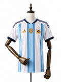 Camisa Argentina 2026 frente manequim madeira fundo branco